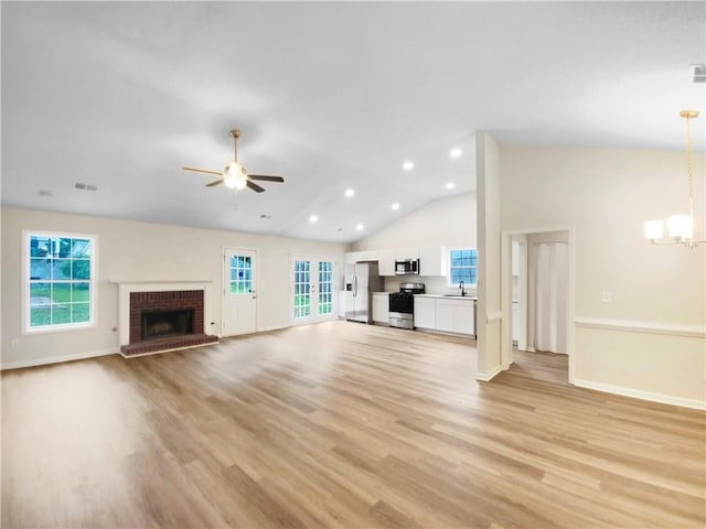 1792 Portwest Way, Hampton, GA 30228 - unfurnished living room featuring ceiling fan, a sink, light wood-style flooring, a chandelier, and a brick fireplace