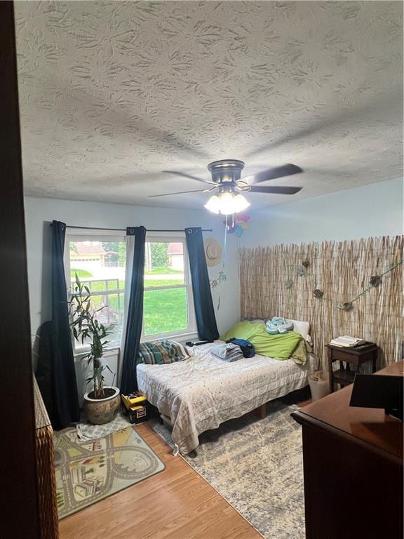 2194 Meadow Dr, Snellville, GA 30078 - bedroom featuring wood finished floors, a textured ceiling, and a ceiling fan