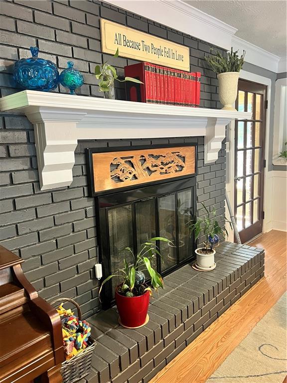 2194 Meadow Dr, Snellville, GA 30078 - detailed view of a brick fireplace, ornamental molding, wood finished floors, and brick wall