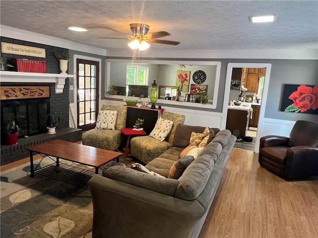 2194 Meadow Dr, Snellville, GA 30078 - living area featuring a textured ceiling, wood finished floors, ceiling fan, wainscoting, and crown molding