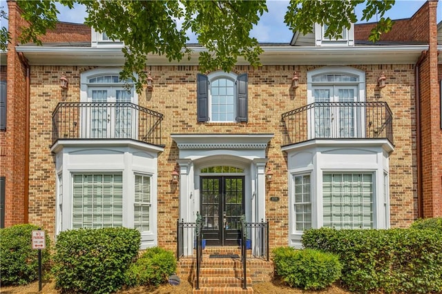 exterior space with brick siding and a balcony