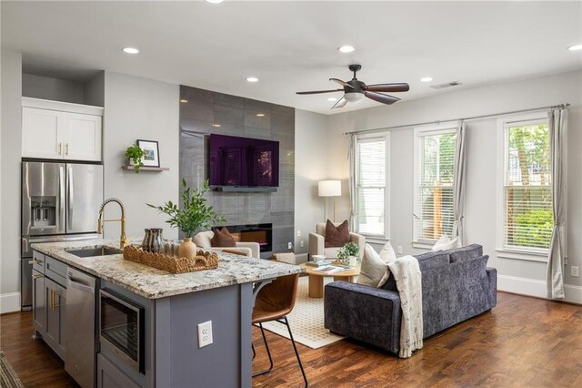 1202 Hardee St NE, Atlanta, GA 30307 - kitchen with open floor plan, a sink, stainless steel appliances, light stone counters, and a ceiling fan