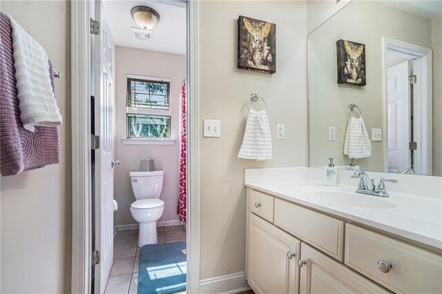 bathroom featuring toilet, tile patterned flooring, vanity, and baseboards