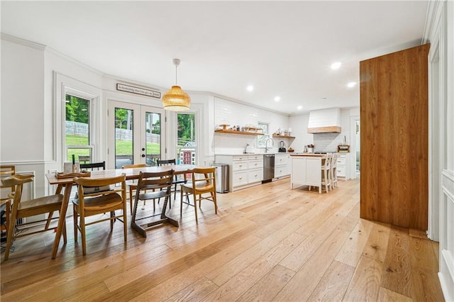 dining space featuring french doors, light wood finished floors, crown molding, and recessed lighting
