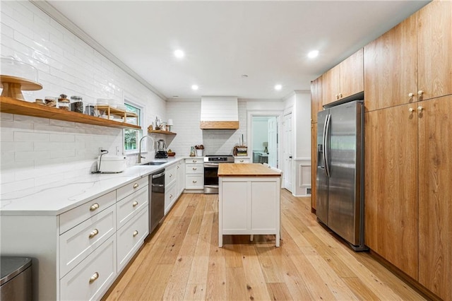 kitchen featuring stainless steel appliances, open shelves, a sink, premium range hood, and light wood-style flooring