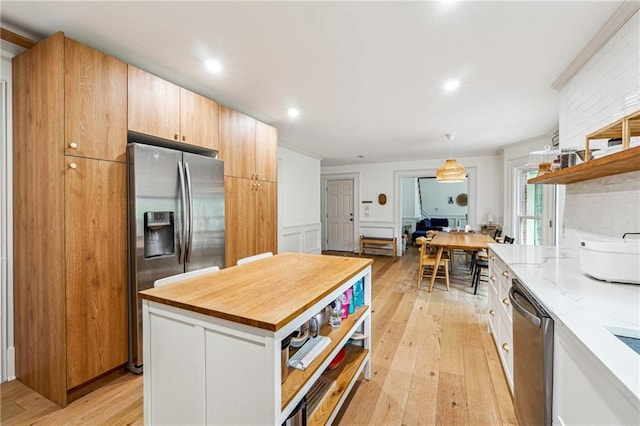kitchen featuring stainless steel appliances, open shelves, light stone countertops, light wood finished floors, and hanging light fixtures