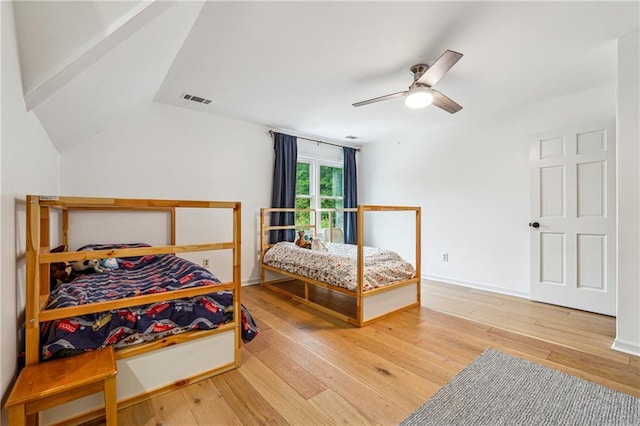 bedroom with hardwood / wood-style flooring, lofted ceiling, ceiling fan, and baseboards