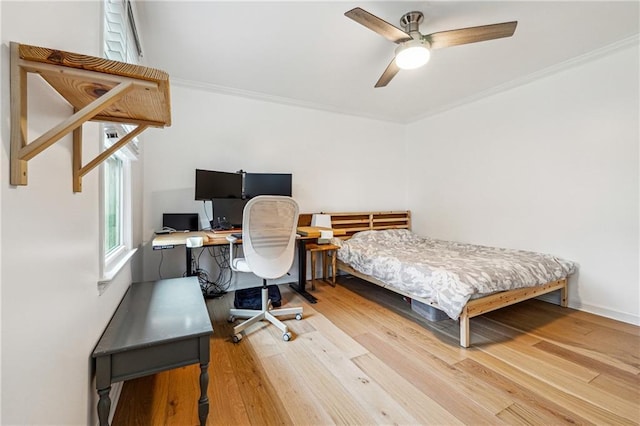 bedroom with ornamental molding, wood finished floors, ceiling fan, and a desk