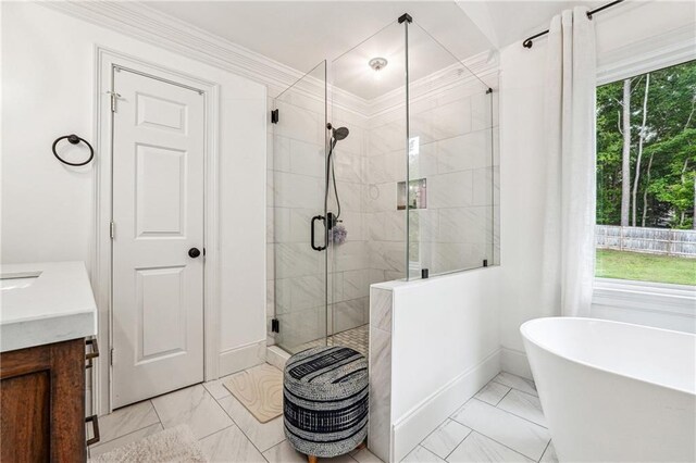 full bath featuring marble finish floors, a stall shower, vanity, a freestanding bath, and crown molding