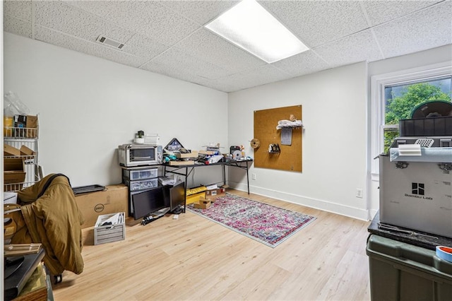 office area featuring a drop ceiling, wood finished floors, and baseboards