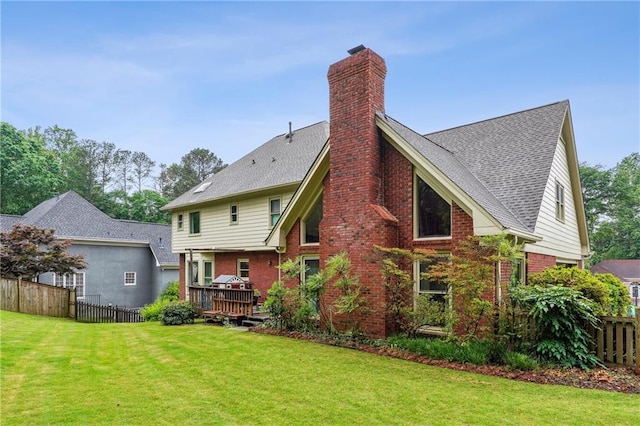 back of house featuring a chimney, brick siding, and a wooden deck