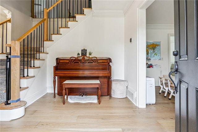 entryway featuring ornamental molding, wood finished floors, and stairs