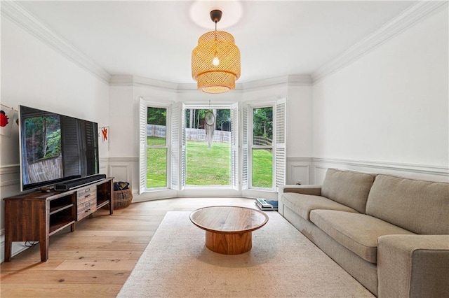 living room with light wood finished floors, wainscoting, and crown molding