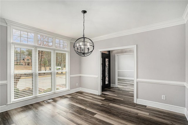 unfurnished dining area featuring crown molding, dark hardwood / wood-style flooring, and a notable chandelier