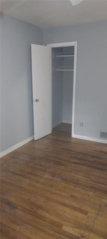 unfurnished bedroom with a closet and dark hardwood / wood-style flooring