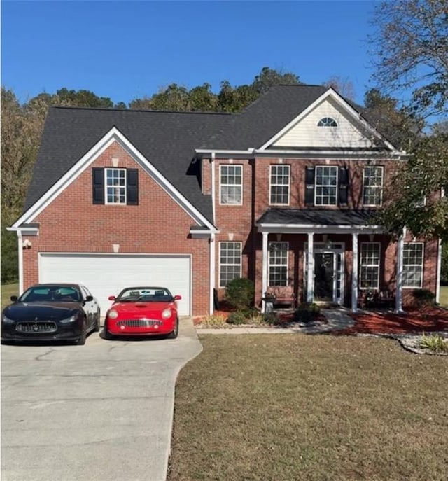 colonial-style house featuring a front lawn, covered porch, and a garage