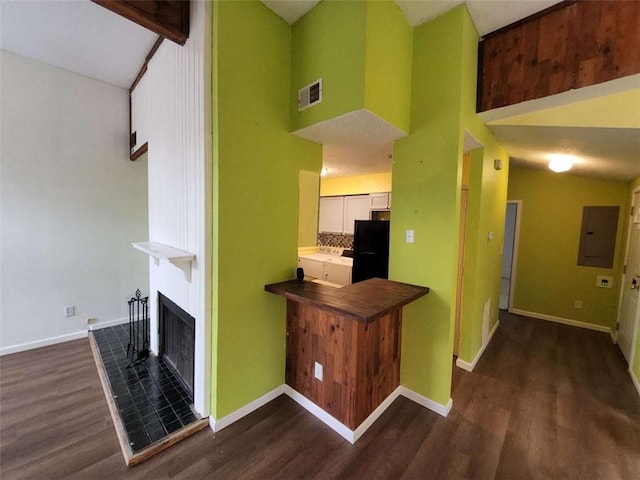 interior space featuring beamed ceiling, a fireplace, dark hardwood / wood-style floors, and electric panel