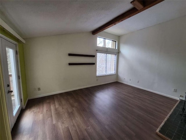 empty room featuring dark wood-type flooring, lofted ceiling with beams, and a textured ceiling