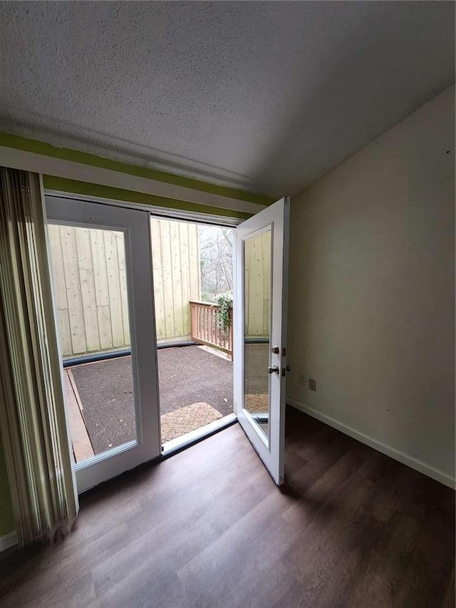 doorway to outside featuring wood-type flooring and a textured ceiling