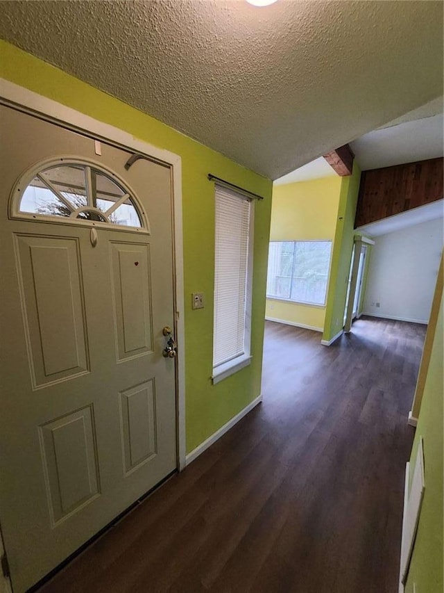 foyer entrance with dark hardwood / wood-style floors and a textured ceiling