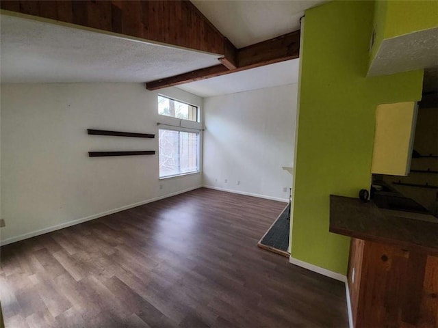 interior space featuring vaulted ceiling with beams and dark hardwood / wood-style floors