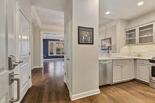 kitchen with appliances with stainless steel finishes, sink, white cabinets, backsplash, and crown molding