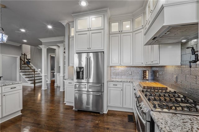 kitchen with dark hardwood / wood-style flooring, decorative backsplash, custom range hood, ornate columns, and premium appliances