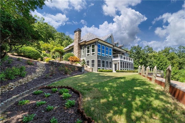 rear view of property with a yard and a sunroom