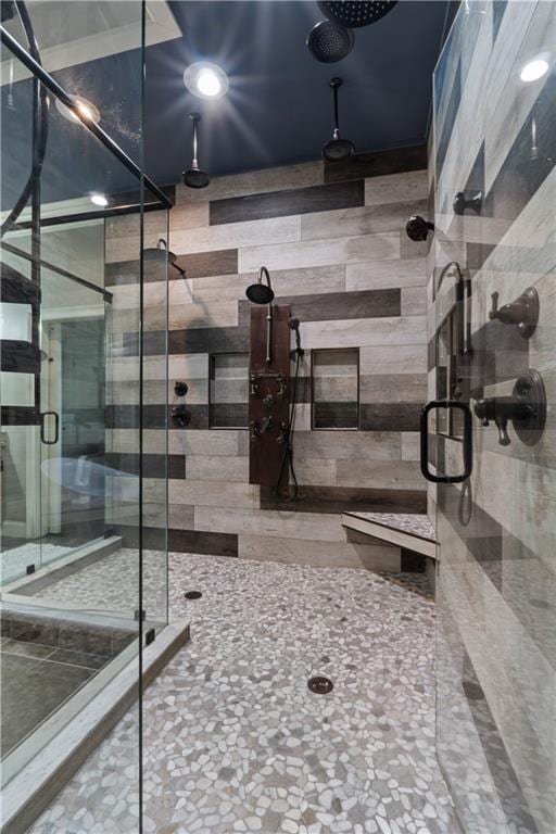 bathroom featuring wood walls and a shower with shower door