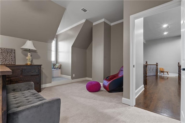 sitting room with lofted ceiling, wood-type flooring, and crown molding