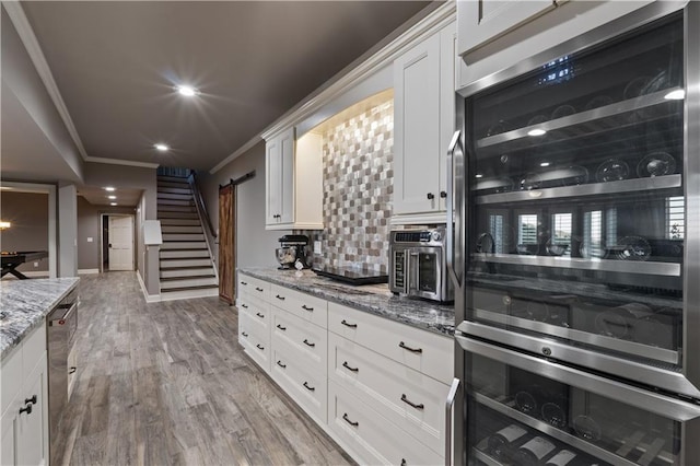 kitchen featuring ornamental molding, white cabinetry, stainless steel appliances, and tasteful backsplash