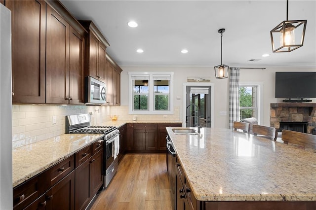 415 Stoneledge Rd, Jasper, GA 30143 - kitchen with stainless steel appliances, crown molding, light stone countertops, backsplash, and a fireplace