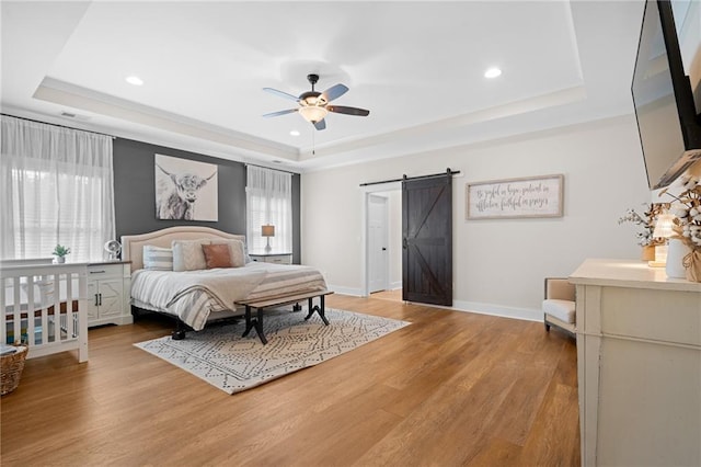 415 Stoneledge Rd, Jasper, GA 30143 - bedroom featuring a tray ceiling, a barn door, recessed lighting, and light wood-style flooring