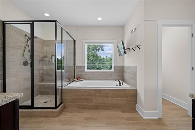 415 Stoneledge Rd, Jasper, GA 30143 - bathroom with vanity, a stall shower, a garden tub, wood finished floors, and recessed lighting