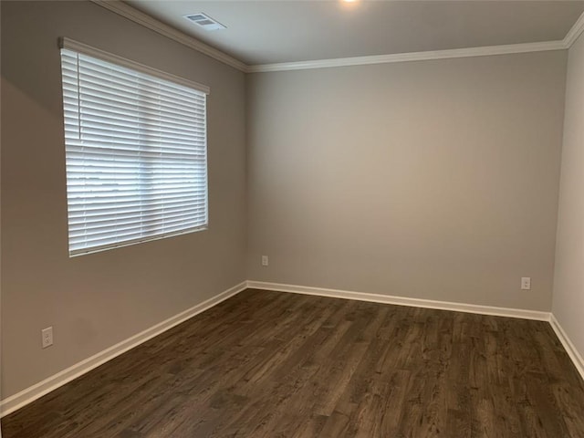 empty room featuring dark wood-type flooring and ornamental molding