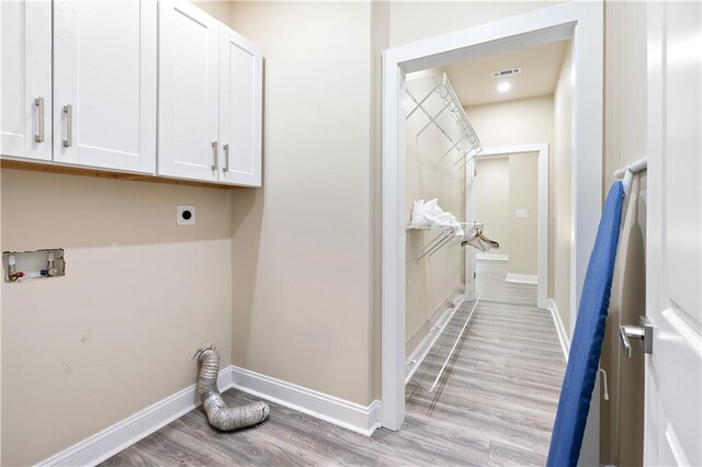 washroom with washer hookup, cabinets, hookup for an electric dryer, and light wood-type flooring