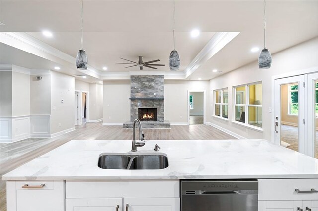 kitchen featuring white cabinetry, sink, decorative light fixtures, and stainless steel dishwasher