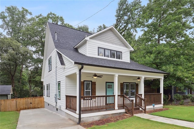 view of front facade featuring a ceiling fan, a porch, fence, and a front lawn