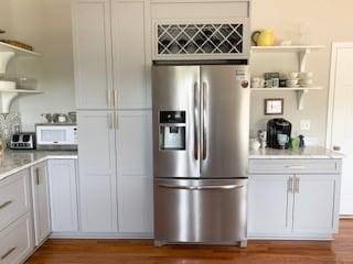 337 Long Shore Way, Newnan, GA 30265 - kitchen featuring stainless steel refrigerator with ice dispenser, open shelves, wood finished floors, light countertops, and white microwave