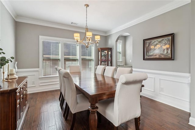 5365 Vendelay Ln, Cumming, GA 30040 - dining room with a chandelier, arched walkways, dark wood-type flooring, wainscoting, and ornamental molding