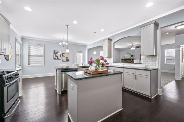 kitchen with a peninsula, tasteful backsplash, stainless steel appliances, and crown molding