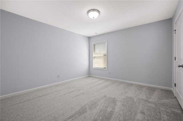 unfurnished room featuring carpet and baseboards