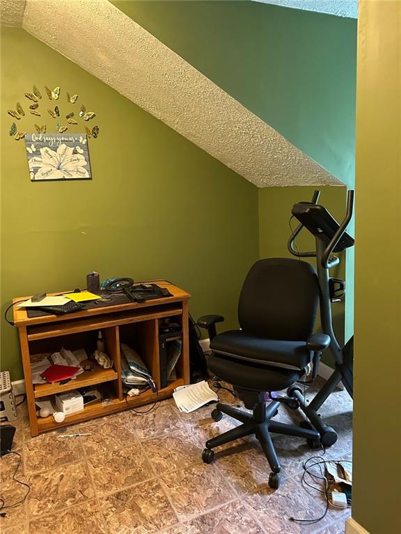 office with vaulted ceiling and a textured ceiling