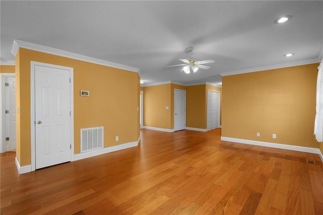 spare room featuring visible vents, light wood-style flooring, and ornamental molding