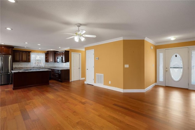 kitchen with wood finished floors, visible vents, appliances with stainless steel finishes, and a kitchen island