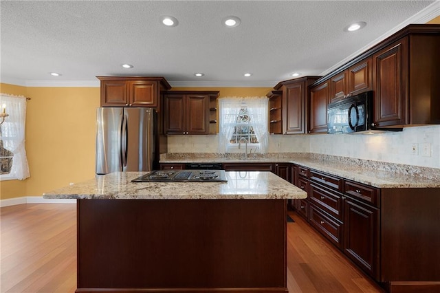 kitchen featuring light wood-type flooring, open shelves, freestanding refrigerator, black microwave, and stovetop with downdraft