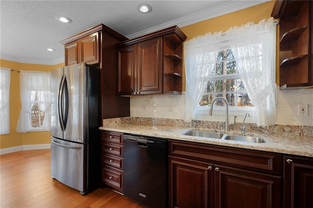 kitchen with dishwasher, open shelves, freestanding refrigerator, and a sink