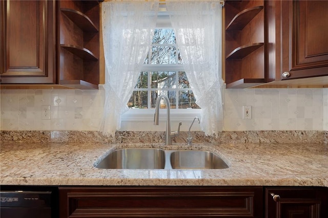 kitchen featuring open shelves, black dishwasher, light stone countertops, and a sink