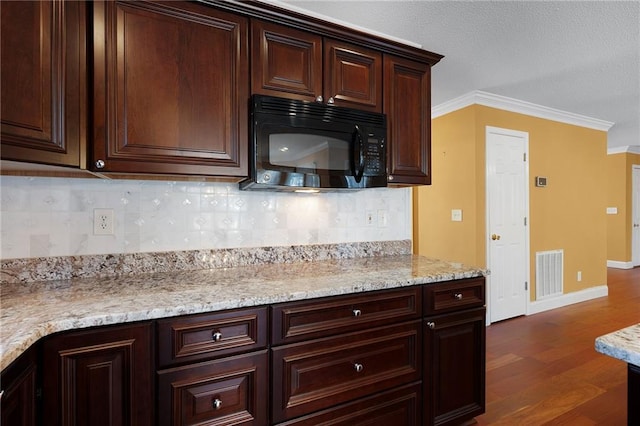 kitchen with visible vents, dark wood-style flooring, black microwave, and crown molding