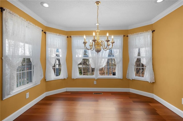 unfurnished dining area with visible vents, baseboards, a chandelier, and hardwood / wood-style flooring